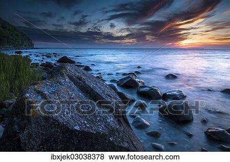 Stock Photo - "Rocks on a beach at sunset by the sea, bei Nardewitz, Rugen island, Rugen, Mecklenburg-Western Pomerania, Germany, Europe". Fotosearch