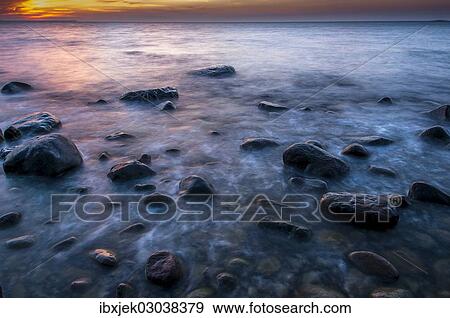 "Rocks on a beach at sunset by the sea, bei Nardewitz, Rugen island, Rugen, Mecklenburg-Western Pomerania, Germany, Europe" View Large Photo Image Stock Photo - "Rocks on a beach at sunset by the sea, bei Nardewitz, Rugen island, Rugen, Mecklenburg-Western Pomerania, Germany, Europe". Fotosearch
