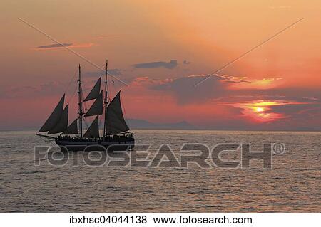 Stock Photo - "Sailboat at Oia sunset, Santorini, Cyclades, Aegean Sea, Greece, Europe". Fotosearch
