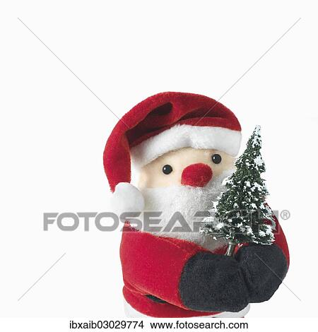 Santa Claus doll holding a Christmas tree View Large Photo Image Picture - Santa Claus doll holding a Christmas tree. Fotosearch