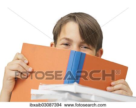 "Schoolboy behind a school book, looking pleased" View Large Photo Image Picture - "Schoolboy behind a school book, looking pleased". Fotosearch