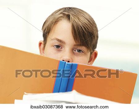 "Schoolboy behind a school book, looking tired, frustrated" View Large Photo Image Stock Photo - "Schoolboy behind a school book, looking tired, frustrated". Fotosearch