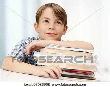 "Schoolboy with a stack of books, smiling, dreamy" View Large Photo Image Stock Photo - "Schoolboy with a stack of books, smiling, dreamy". Fotosearch