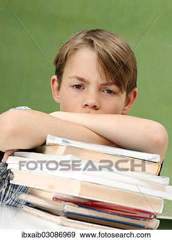 "Schoolboy with a stack of books, looking frustrated, tired" View Large Photo Image Stock Photo - "Schoolboy with a stack of books, looking frustrated, tired". Fotosearch
