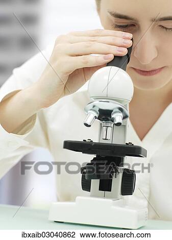 Scientist looking through a microscope View Large Photo Image Stock Image - Scientist looking through a microscope. Fotosearch
