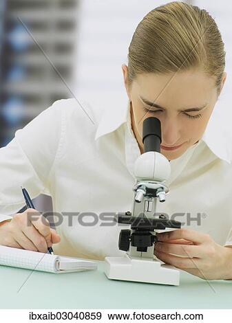 Scientist looking through a microscope View Large Photo Image Stock Photo - Scientist looking through a microscope. Fotosearch