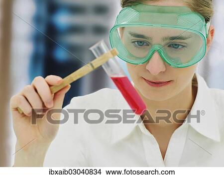 Picture - Scientist wearing a protective mask and holding a test tube. Fotosearch