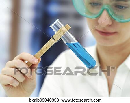 Scientist wearing a protective mask and holding a test tube View Large Photo Image Stock Photo - Scientist wearing a protective mask and holding a test tube. Fotosearch