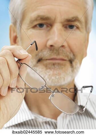 Stock Photography - "Senior, holding a pair of glasses". Fotosearch