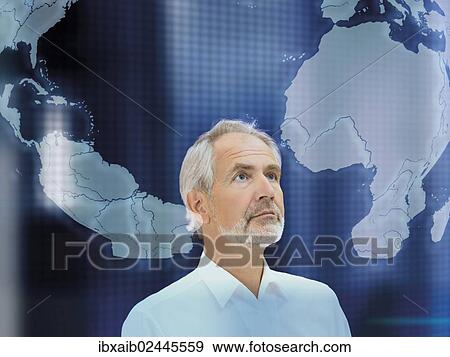 Stock Photo - "Senior, looking at a map of the world". Fotosearch