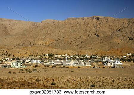 "Settlement with a mosque in a plain at the foot of the barren mountains of the Al Hajar Mountains, Sultanate of Oman, Middle East" View Large Photo Image Stock Image - "Settlement with a mosque in a plain at the foot of the barren mountains of the Al Hajar Mountains, Sultanate of Oman, Middle East". Fotosearch