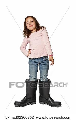 Seven-year-old girl wearing gumboots that are far too big View Large Photo Image Stock Image - Seven-year-old girl wearing gumboots that are far too big. Fotosearch