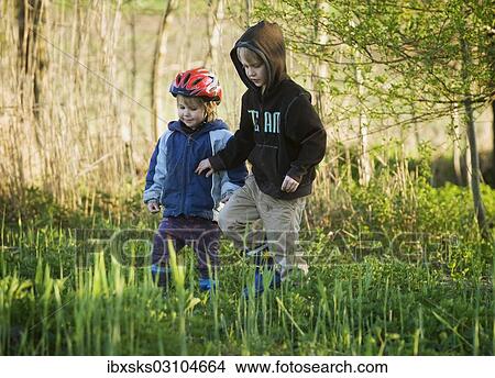 Picture - "Siblings, boy, 8, and girl, 4, playing together at the shore of a pond, Crailsheim, Hohenlohe, Baden-Wurttemberg, Germany, Europe". Fotosearch