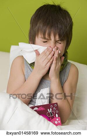 Sick boy in bed blowing his nose View Large Photo Image Stock Photo - Sick boy in bed blowing his nose. Fotosearch