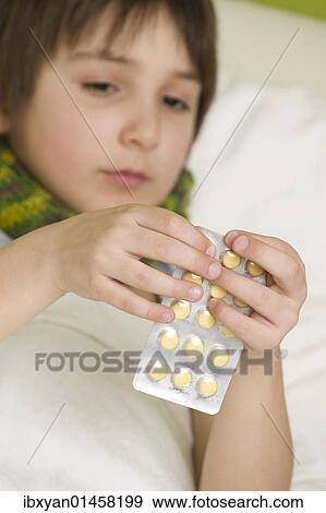 Sick boy taking tablets View Large Photo Image Stock Photo - Sick boy taking tablets. Fotosearch