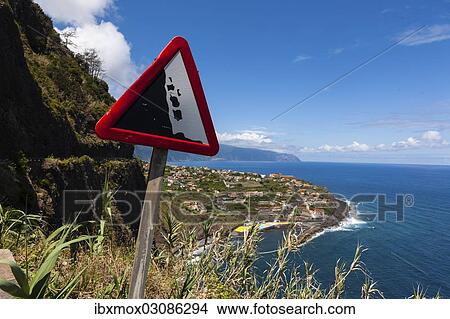 Picture - "Sign, """"Beware falling rocks"""" on a country road along the coastal cliffs near Ponta Delgada, Vicente, Boaventura, Madeira, Portugal, Europe". Fotosearch