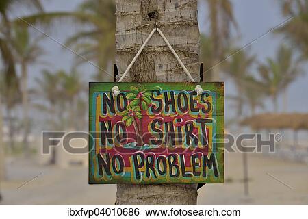 Stock Photograph - "Sign """"No shoes, no shirt, no problem"""" on the beach of Salalah Rotana Resort, Salalah, Dhofar Region, Oman, Asia". Fotosearch