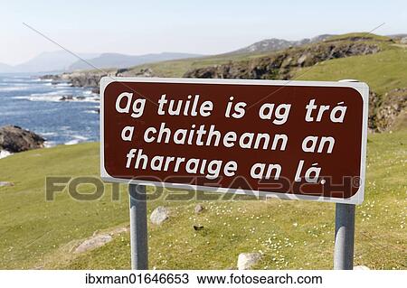 Stock Image - "Sign with Irish lettering, Irish Gaelic lettering, Achill Island, County Mayo, Connacht province, Republic of Ireland, Europe". Fotosearch