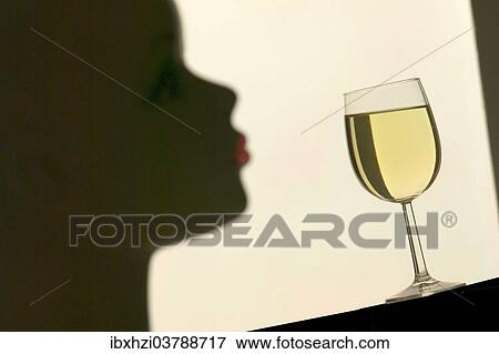 Silhouette in front of a glass with white wine View Large Photo Image Stock Photo - Silhouette in front of a glass with white wine. Fotosearch