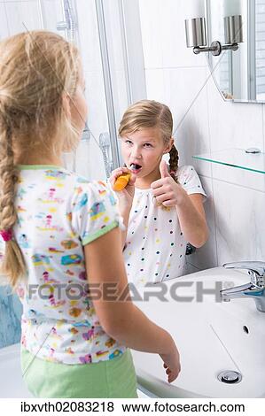 Sisters brushing teeth in the bathroom View Large Photo Image Stock Photo - Sisters brushing teeth in the bathroom. Fotosearch