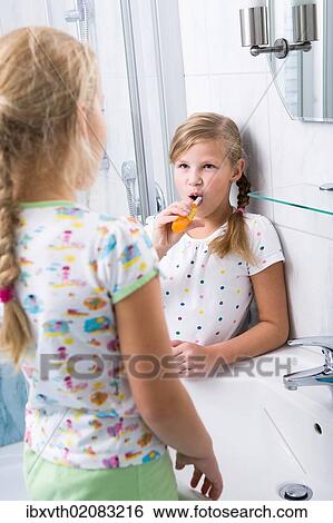 Stock Photograph - Sisters brushing teeth in the bathroom. Fotosearch
