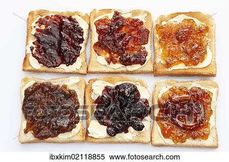 Stock Photography - "Six slices of toast with various jams, rhubarb jam, apricot jam, strawberry jam, orange marmalade, cherry jam and ginger marmalade". Fotosearch