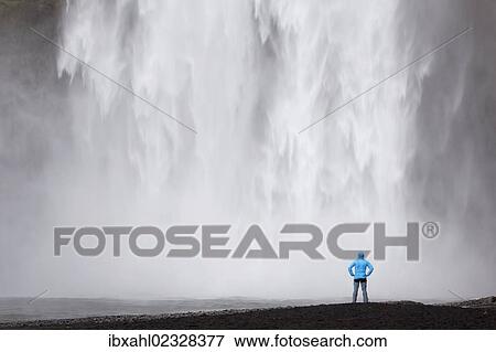 Stock Photo - "Skogafoss waterfall with a hiker, Skogar, South Iceland, Iceland, Europe". Fotosearch