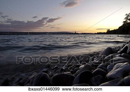 "Skyline of Konstanz with gravel beach shortly after sunset seen from the Konstanzer Hoernle, Lake Constance, Konstanzer Trichter bay, Konstanz, Baden-Wuerttemberg, Germany, Europe" View Large Photo Image Stock Photo - "Skyline of Konstanz with gravel beach shortly after sunset seen from the Konstanzer Hoernle, Lake Constance, Konstanzer Trichter bay, Konstanz, Baden-Wuerttemberg, Germany, Europe". Fotosearch