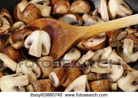 Sliced mushroom in a pan with a wooden spoon View Large Photo Image Stock Image - Sliced mushroom in a pan with a wooden spoon. Fotosearch