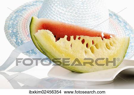 "Slices of melon on a plate in front of a sun hut, symbolic image of a holiday in the south" View Large Photo Image Picture - "Slices of melon on a plate in front of a sun hut, symbolic image of a holiday in the south". Fotosearch