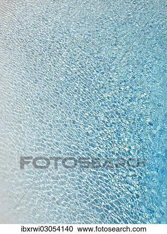 Stock Image - Slightly ruffled turquoise-coloured surface of water in a swimming pool. Fotosearch
