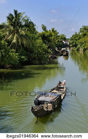 "Small wooden motorboat passing through a water channel surrounded by tropical vegetation, Hue, Vietnam, Asia" View Large Photo Image Picture - "Small wooden motorboat passing through a water channel surrounded by tropical vegetation, Hue, Vietnam, Asia". Fotosearch