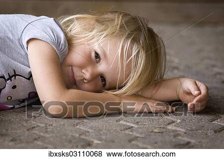 "Smiling girl, 4, lying on the ground, Crailsheim, Hohenlohe, Baden-Wurttemberg, Germany, Europe" View Large Photo Image Stock Photo - "Smiling girl, 4, lying on the ground, Crailsheim, Hohenlohe, Baden-Wurttemberg, Germany, Europe". Fotosearch