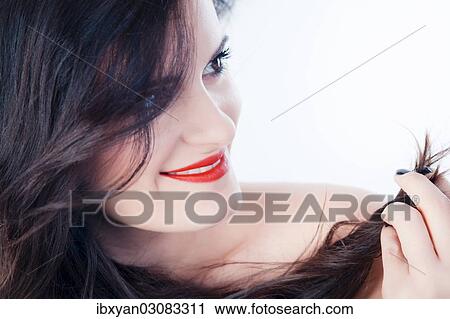 Smiling young woman with red lips playing with her hair View Large Photo Image Stock Image - Smiling young woman with red lips playing with her hair. Fotosearch