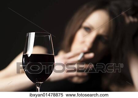 Stock Photography - Smoking woman with a glass of wine. Fotosearch