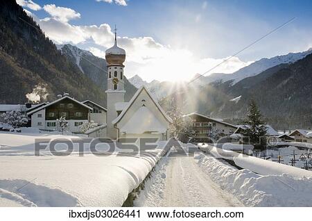 Stock Image - "Snow-covered church and sun rays, St Gallenkirch, Montafon, Vorarlberg, Austria, Europe". Fotosearch