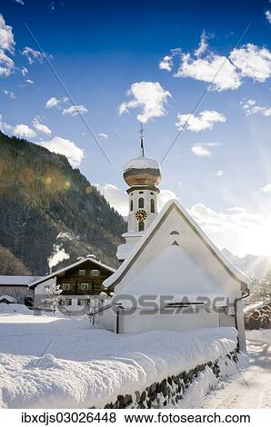 Stock Photo - "Snow-covered church and sun rays, St Gallenkirch, Montafon, Vorarlberg, Austria, Europe". Fotosearch
