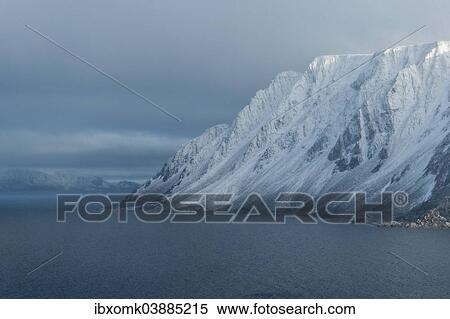 Stock Photography - "Snow-covered mountains in light snowfall, Reliktbukta, Nordaustland, Svalbard archipelago, Svalbard and Jan Mayen, Norway, Europe". Fotosearch