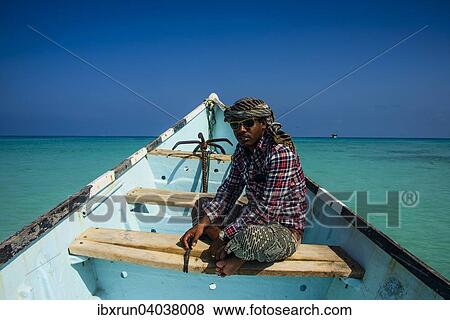 "Socotran man sitting in fishing boat, Qalansia, island of Socotra, Yemen, Asia" View Large Photo Image Stock Photo - "Socotran man sitting in fishing boat, Qalansia, island of Socotra, Yemen, Asia". Fotosearch