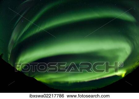 Stock Photograph - "Spiral, swirling green northern polar lights, Aurora borealis, near Whitehorse, Yukon Territory, Canada, North America". Fotosearch