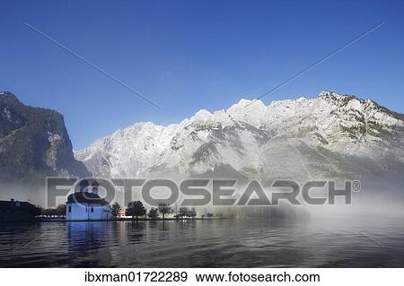 Stock Photo - "St. Bartholomae church, morning fog on Lake Koenigssee, Mt. Watzmann, Nationalpark Berchtesgaden national park, Berchtesgadener Land, Upper Bavaria, Bavaria, Germany, Europe". Fotosearch