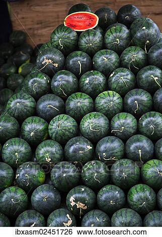 Stock Photograph - "Stacked Watermelons (Citrullus lanatus) with a half cut melon, Chiang Mai, Northern Thailand, Thailand, Asia". Fotosearch