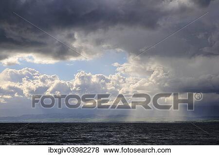 "Storm clouds and sunbeams above Lake Geneva, Lac Leman, Evian-les-Bains, Haute-Savoie, Rhone-Alpes, France, Europe" View Large Photo Image Stock Photo - "Storm clouds and sunbeams above Lake Geneva, Lac Leman, Evian-les-Bains, Haute-Savoie, Rhone-Alpes, France, Europe". Fotosearch