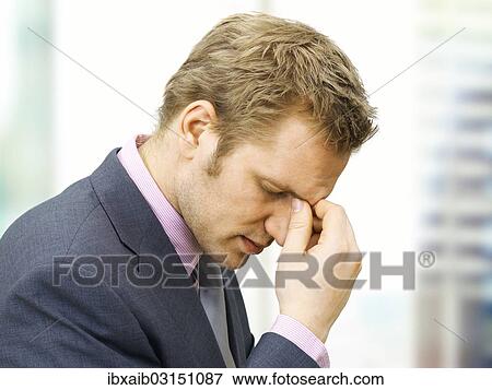 Stressed businessman holding a hand to the bridge of his nose View Large Photo Image Stock Photo - Stressed businessman holding a hand to the bridge of his nose. Fotosearch