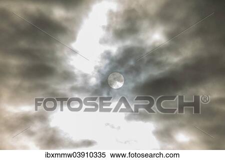 Stock Photography - Sun behind dark clouds. Fotosearch