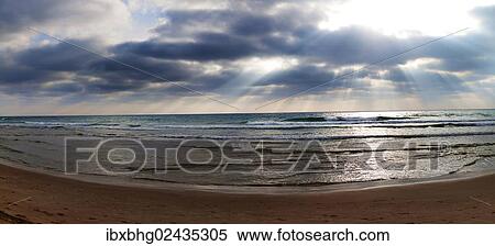 Stock Photography - "Sun rays breaking through clouds, panoramic view of the beach at Atlit, Israel, Asia". Fotosearch