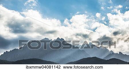 "Sun through clouds against mountains, silhouette of the mountains with Monte Cinto, Col de Vergio, Cinto Massif, Corsica, France, Europe" View Large Photo Image Stock Image - "Sun through clouds against mountains, silhouette of the mountains with Monte Cinto, Col de Vergio, Cinto Massif, Corsica, France, Europe". Fotosearch