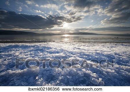 "Sunlight with moody clouds, stacked ice floes on the shore of Reichenau Island, Baden-Wuerttemberg, Germany, Europe" View Large Photo Image Stock Photograph - "Sunlight with moody clouds, stacked ice floes on the shore of Reichenau Island, Baden-Wuerttemberg, Germany, Europe". Fotosearch