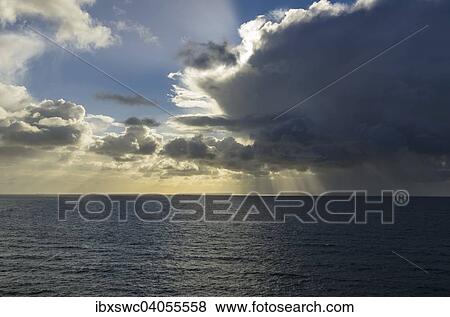 "Sunrays shining through clouds over the sea, bad weather front moving in, North Sea, Heligoland, Schleswig-Holstein, Germany, Europe" View Large Photo Image Stock Photo - "Sunrays shining through clouds over the sea, bad weather front moving in, North Sea, Heligoland, Schleswig-Holstein, Germany, Europe". Fotosearch