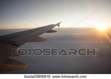 "Sunrise from an airplane above the clouds with wing unit, above Norway" View Large Photo Image Stock Photo - "Sunrise from an airplane above the clouds with wing unit, above Norway". Fotosearch